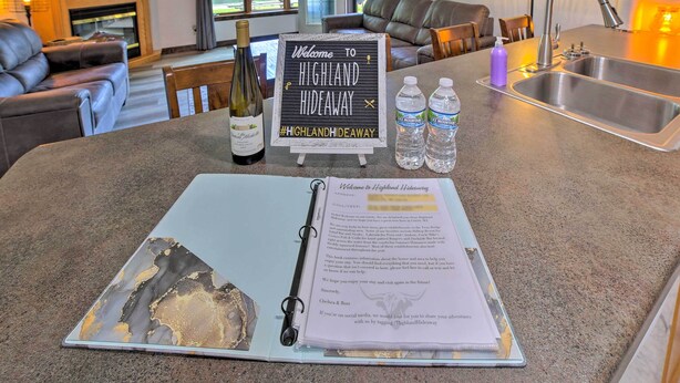A kitchen counter with a welcome sign, a wine bottle, water bottles, and a notebook. - Waterfront Crivitz Property w/ Lake Access! (Crivitz)