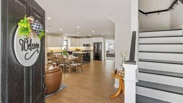 Une cuisine moderne dotée d’un îlot central, de planchers en bois et d’une pancarte accueillante.