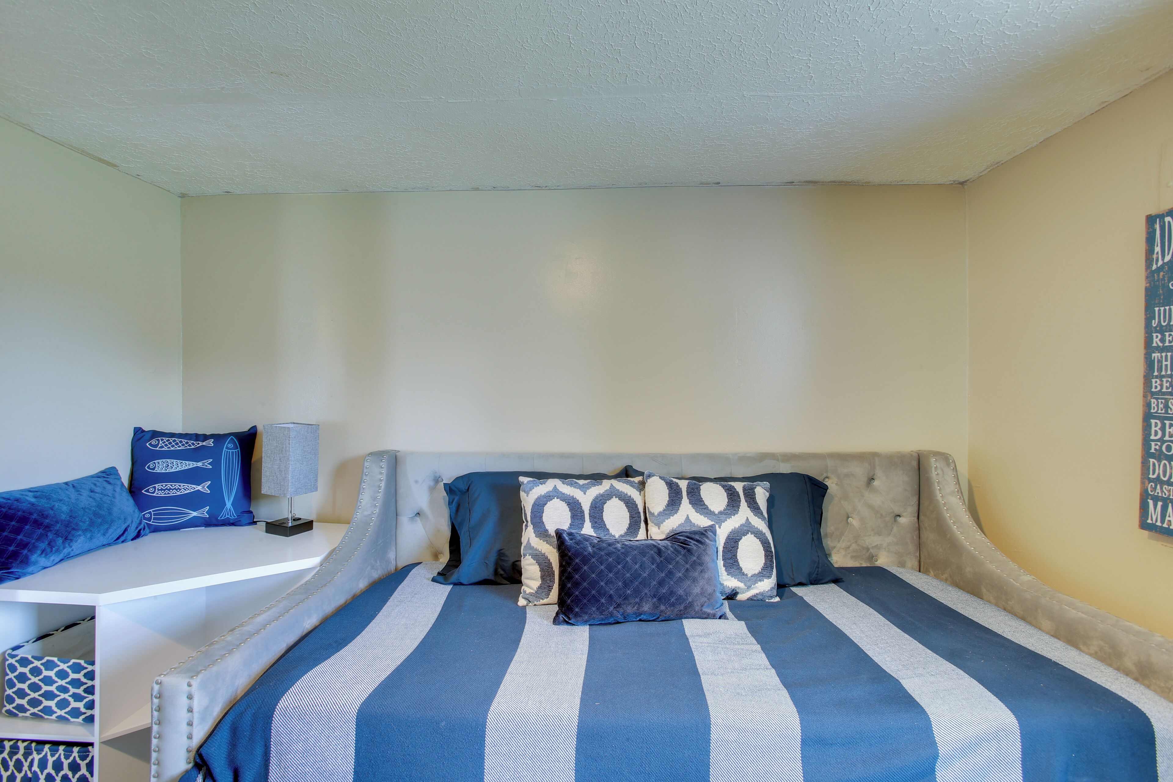Ein Schlafzimmer mit einem Bett, einem Nachttisch und einer Wand mit einer Dekoration.