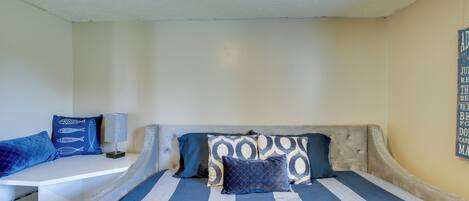 Ein Schlafzimmer mit einem Bett, einem Nachttisch und einer Wand mit einer Dekoration.
