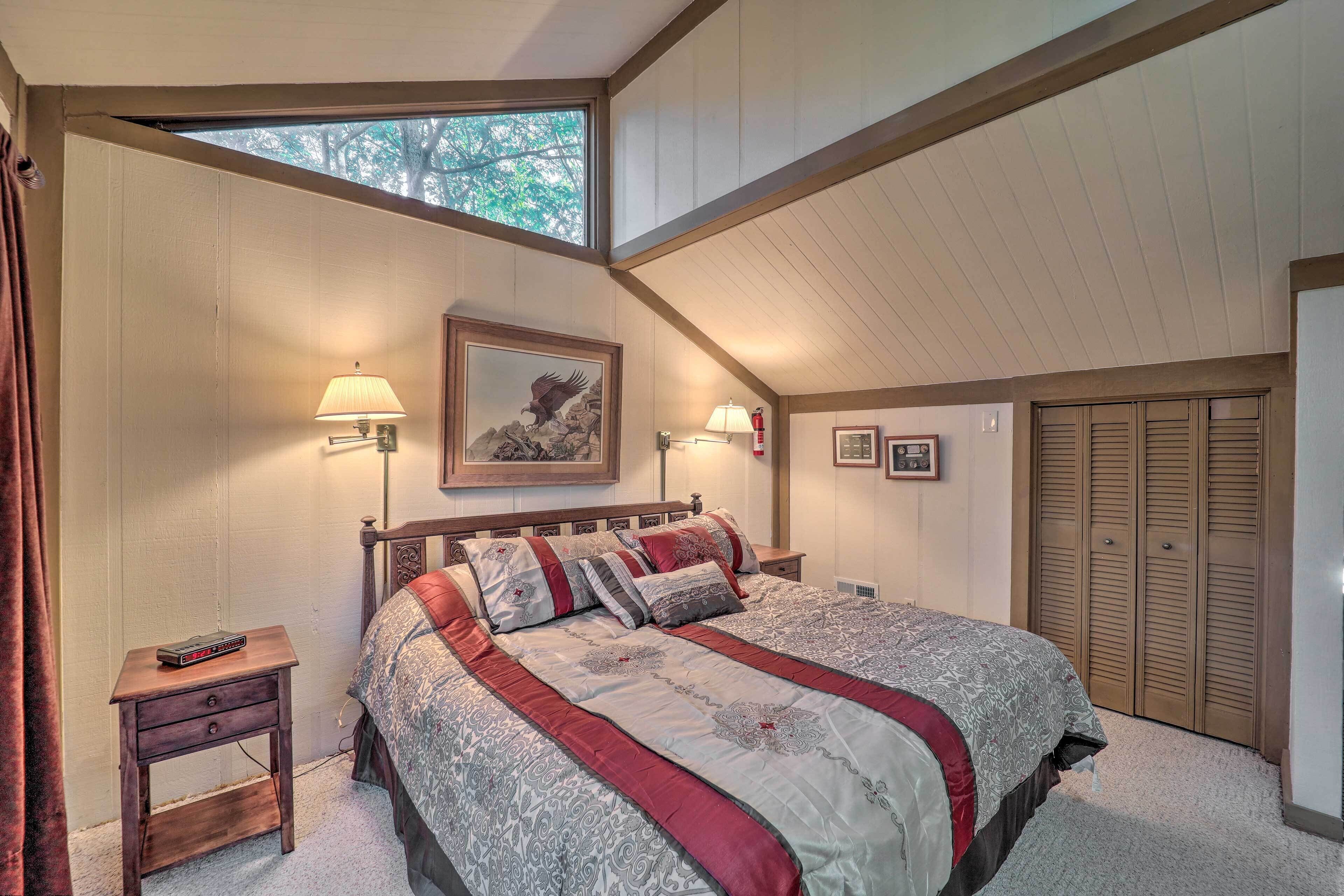 A bedroom with a large bed, two bedside tables, a window, and a wardrobe.