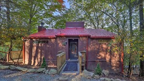 A rustic cabin with a red roof, a wooden door, and a small porch. - Ski Resort Cabin w/ Deck in Beech Mountain! (Banner Elk)