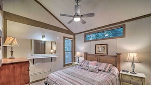A bedroom with a bed, bedside tables, a dresser, a ceiling fan, a window, and a framed picture on the wall. - Ski Resort Cabin w/ Deck in Beech Mountain! (Banner Elk)