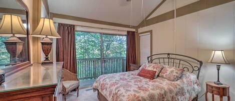A bedroom with a bed, a dresser, a chair, a ceiling fan, and a window with curtains.