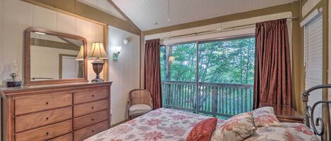 Une chambre à coucher avec un grand lit, une commode, un miroir, une chaise et un balcon avec des rideaux.