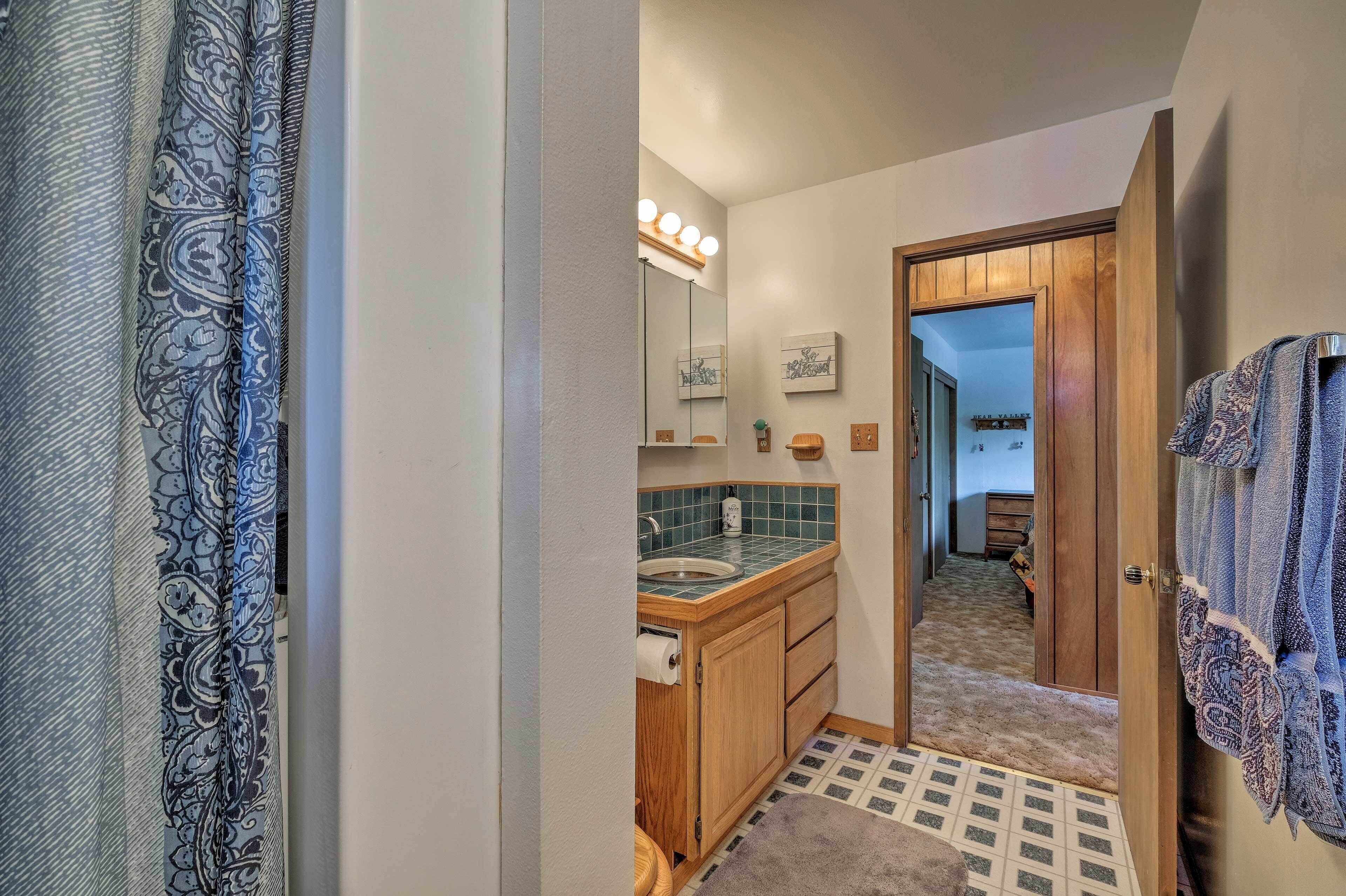 A bathroom with a vanity, mirror, and lights.
