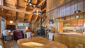 Un intérieur rustique en bois comprenant un coin repas, une cuisine et un espace salon.