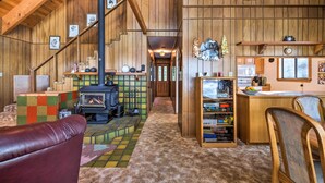Un intérieur rustique avec un escalier en bois, une cheminée et un coin salon confortable.