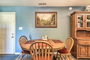 A dining room with a wooden table and chairs, a painting on the wall, and a wooden cabinet. - California Countryside Retreat: Pets Welcome! (Delhi)