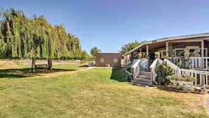 Una casa con porche cubierto, un pequeño jardín y césped.