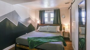 A bedroom with a bed, a nightstand, a window with curtains, and a mirror. - Centrally-located Mountain Getaway in Lead! (Lead)