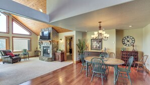 A spacious living room with a fireplace, dining area, and large windows. - Keystone Cabin ~ 9 Mi to Mt Rushmore! (Hermosa)