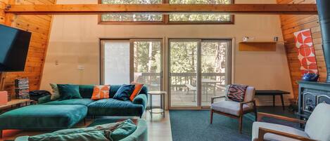A cozy living room with a sectional sofa, a chair, a television, and a fireplace.