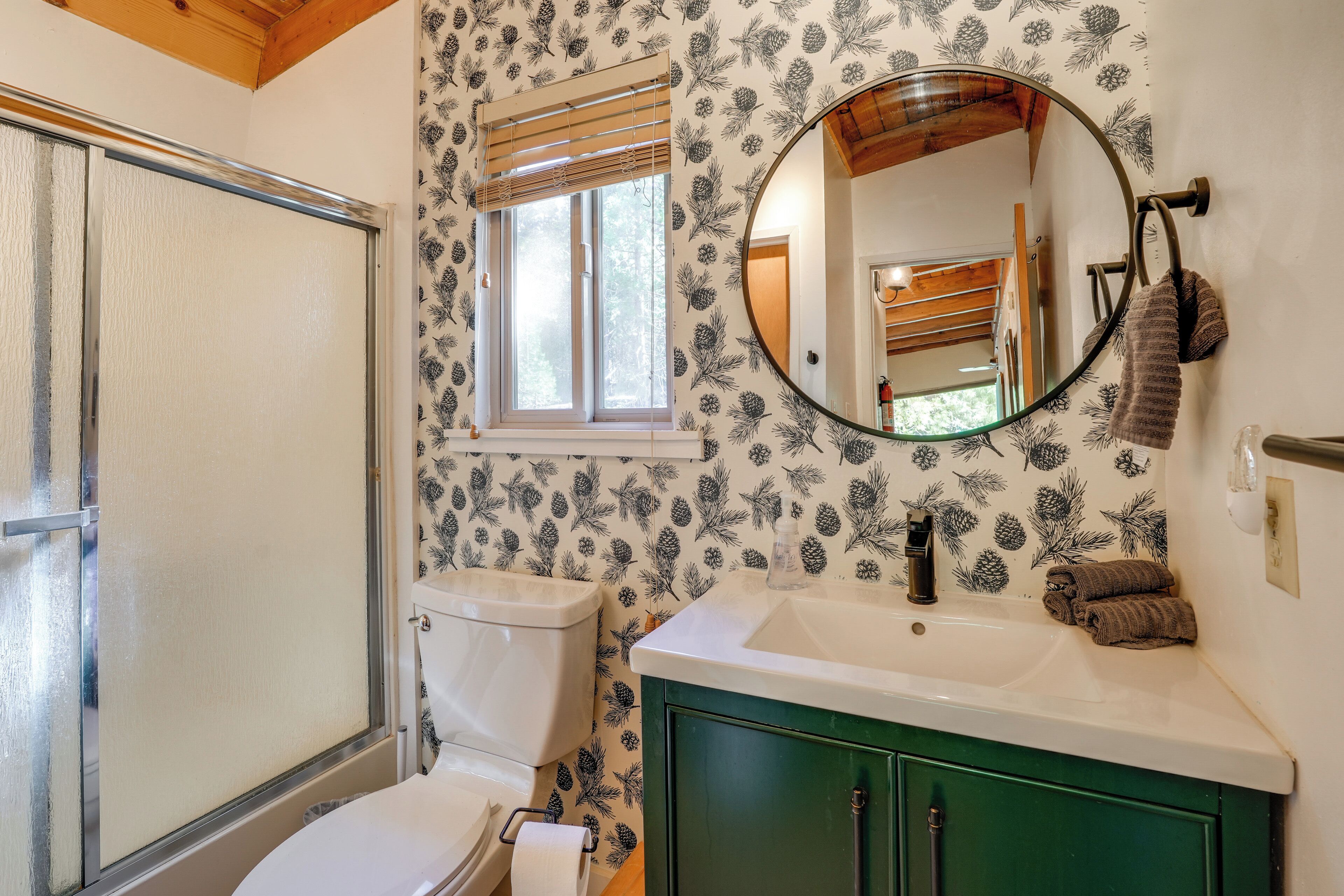A bathroom with a toilet, sink, and mirror.