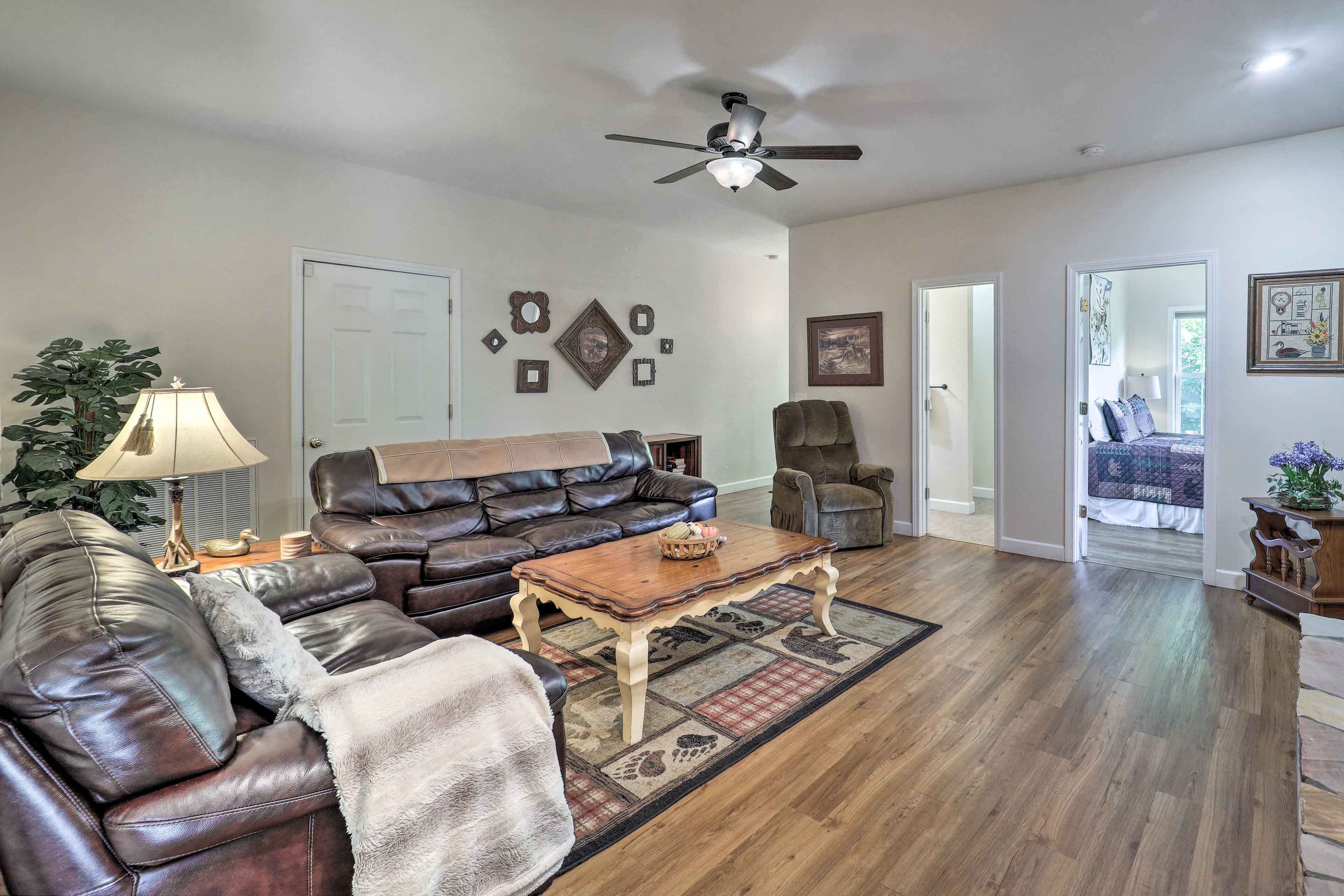 A living room with a leather sofa, a wooden coffee table, and a ceiling fan.