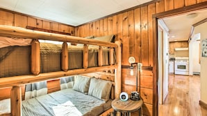 A bunk bed room with wooden walls and a small table with a lamp. - 4 Season, Waterfront Houghton Lake House w/ Dock! (Houghton Lake)