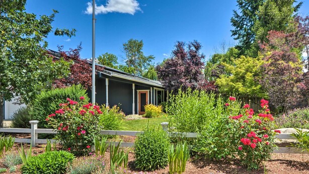 A house with a garden in front, surrounded by various plants and flowers. - Game Room Fun! Medford Family Retreat (Medford)
