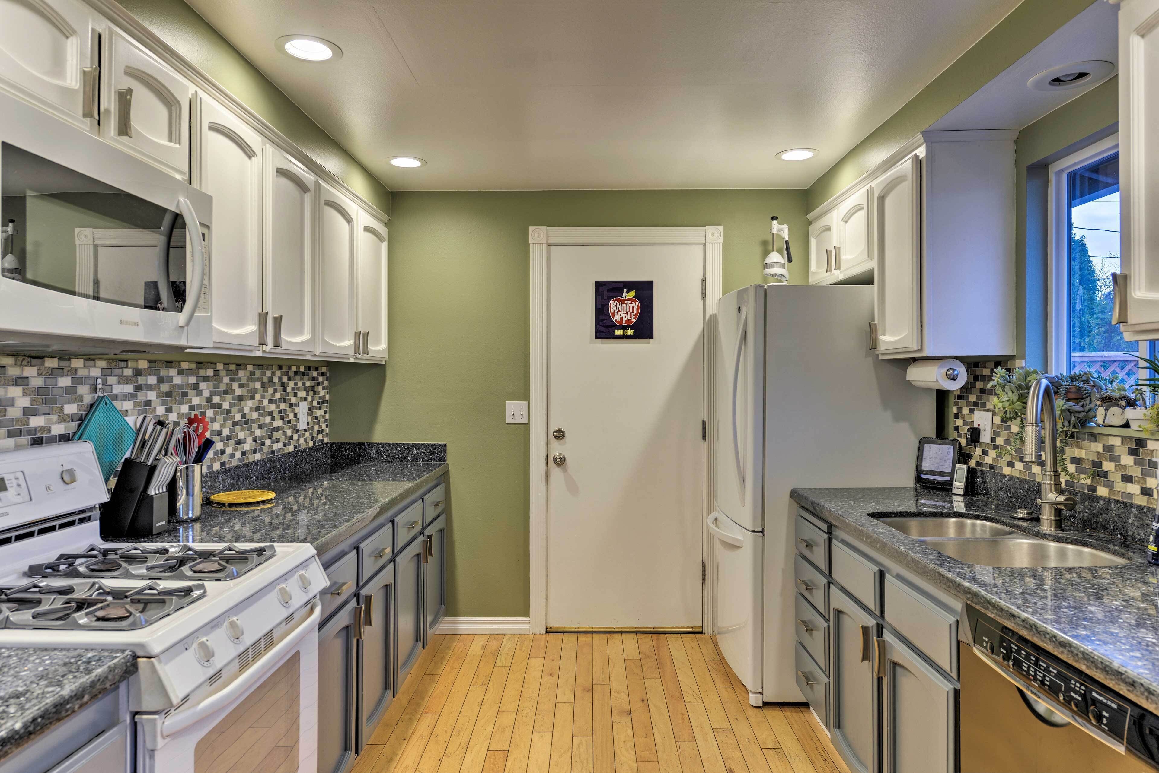 A compact kitchen with white cabinets, a microwave, a stove, and a dishwasher.