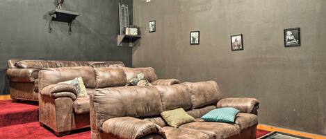 Una habitación con dos sofás de cuero, una mesita y cuadros enmarcados en la pared.