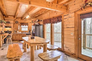 Ein Holzblockhaus-Interieur mit Küche, Essbereich und großen Fenstern.