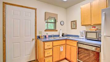 A kitchen with wooden cabinets, a dishwasher, a microwave, and a refrigerator.