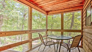 A wooden deck with a glass table and chairs, surrounded by large windows offering a view of a forest. - Bright Davis Escape w/ Screened-in Porch! (Davis)