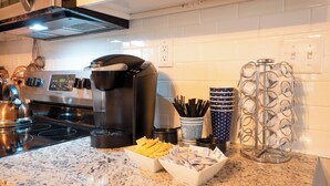 A kitchen with a coffee maker, a kettle, and a bowl of chips on the counter. - Charming Huntsville Home w/ Deck! (Huntsville)