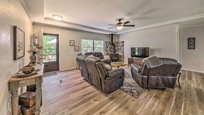 Ein geräumiges Wohnzimmer mit Kamin, Ledersofas und einem Fernseher.