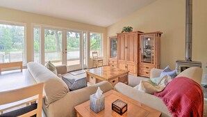 Ein gemütliches Wohnzimmer mit Holztisch, beigen Sofas und einem großen Schrank.