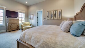 A bedroom with a large bed, a dresser, a chair, and a ceiling fan. - Carlton Landing Retreat w/ Eufaula Lake Access! (Eufaula)