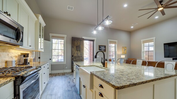 A modern kitchen with granite countertops, stainless steel appliances, and a central island with seating. - Carlton Landing Retreat w/ Eufaula Lake Access! (Eufaula)