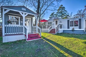 A row of two-story cabins with a porch, steps, and a red umbrella. - Cozy 'mona Lisa Villa - Near Downtown Hot Springs (Hot Springs)