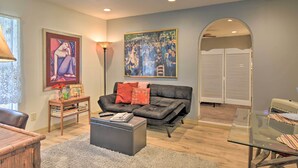 A living room with a black leather sofa, a glass coffee table, and a framed painting on the wall. - Cozy 'mona Lisa Villa - Near Downtown Hot Springs (Hot Springs)