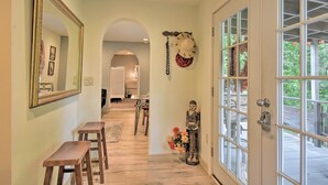 A hallway with a mirror, two wooden stools, a Buddha statue, and a door leading to an outdoor deck. - Cozy 'mona Lisa Villa - Near Downtown Hot Springs (Hot Springs)