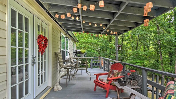 A covered porch with a wooden deck, outdoor furniture, and a decorative wreath. - Cozy 'mona Lisa Villa - Near Downtown Hot Springs (Hot Springs)