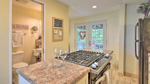 A kitchen with a gas stove, a refrigerator, and a window with a view of greenery. - Cozy 'mona Lisa Villa - Near Downtown Hot Springs (Hot Springs)