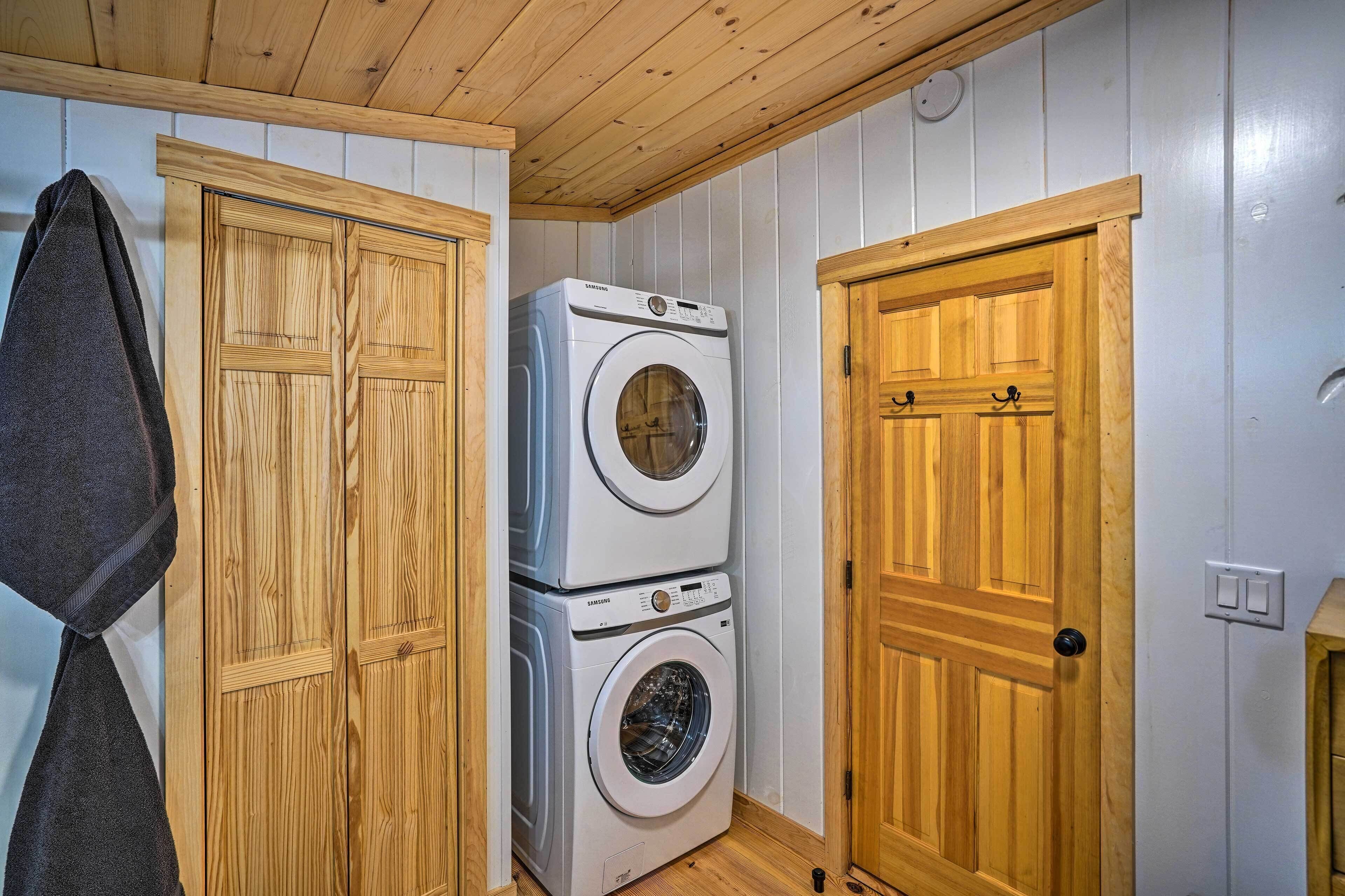 A laundry room with wooden cabinets and stacked washing machines.