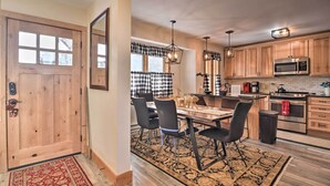 A kitchen with wooden cabinets, a microwave, and a dining area with a table and chairs. - Cozy Mountain Getaway w/ Ski Shuttle Access! (Fraser)