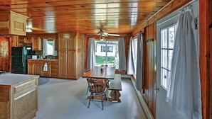 A cabin-style kitchen with wooden cabinets, a dining table, and a bench. - 2 Mi to Boat Ramp! Family Cabin on Long Lake (Hale)
