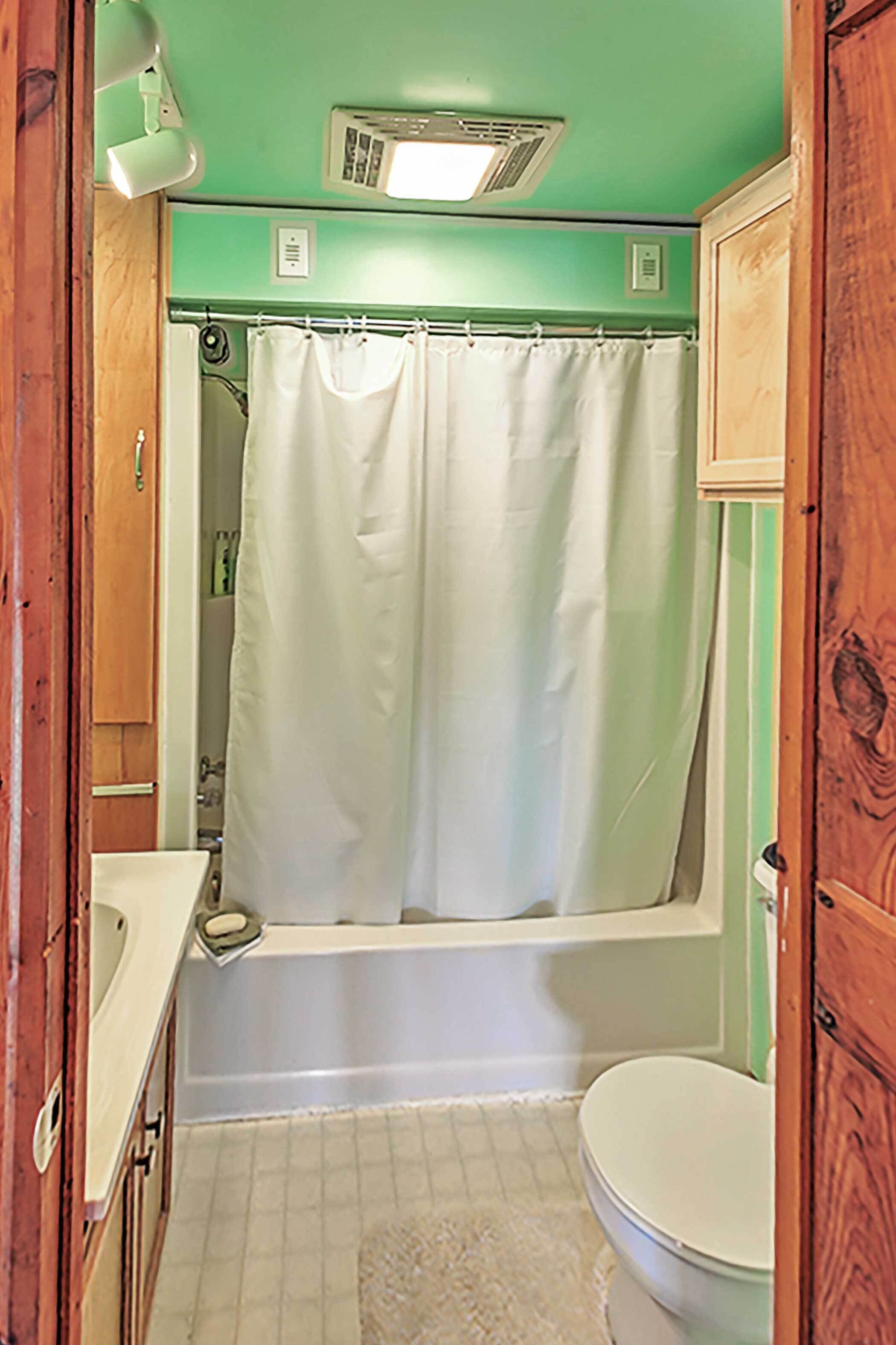 Ein Badezimmer mit Badewanne, Toilette und Duschvorhang.