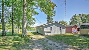 A single-story house with a garage, a small shed, and a dock by a lake. - 2 Mi to Boat Ramp! Family Cabin on Long Lake (Hale)