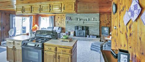 A kitchen with wooden cabinets, a stove, and a microwave.