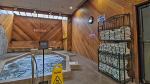 A spa area with wooden walls, a hot tub, and a sign indicating a capacity of 10 persons. - Bellaire Ski Escape ~ 1 Mile to Schuss Mountain! (Bellaire)