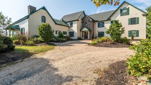 A large, two-story house with a gravel driveway and a well-maintained garden. - Historic Virginia Wine Country Villa w/ Pool, Yard (Linden)