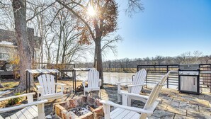 A patio with Adirondack chairs, a fire pit, and a grill. - 'fish House' w/ Deck, Fire Pit & River Views (Cotter)