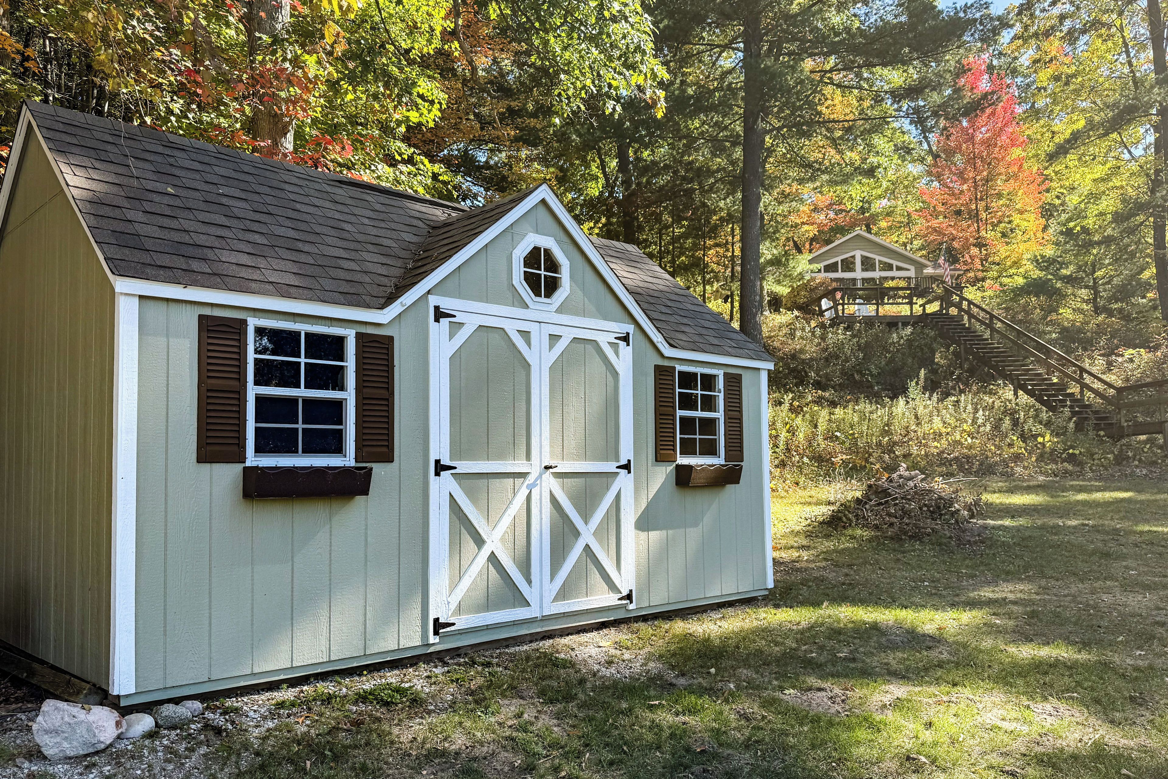 A small, single-story shed with a gabled roof, a central door, and two windows on each side.