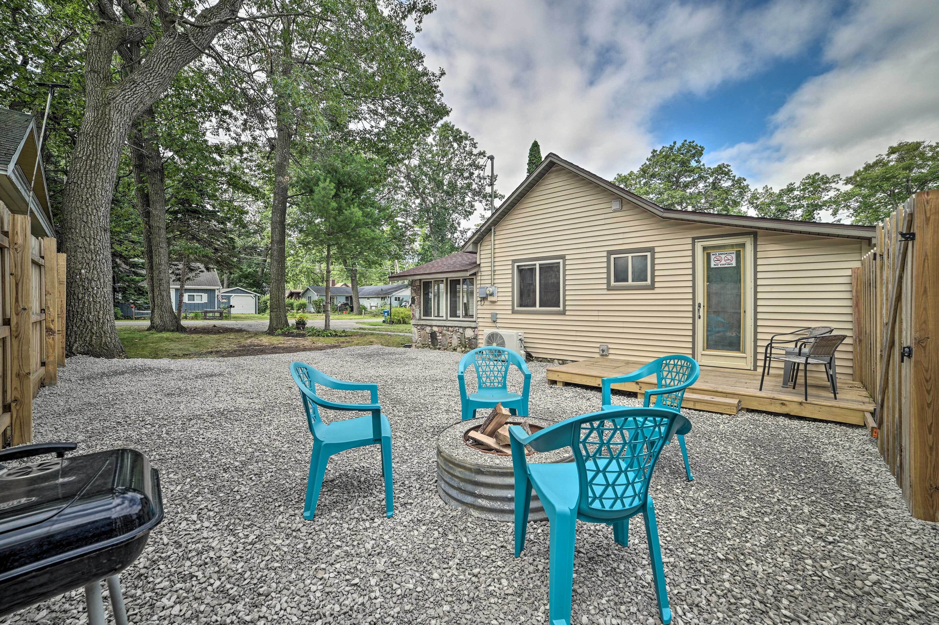 A residential property with a gravel patio, outdoor seating, and a wooden deck.