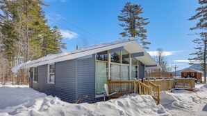 A small cabin with a wooden deck and large windows, surrounded by snow. - Lake Pleasant Access! Speculator Cottage w/ Deck (Speculator)