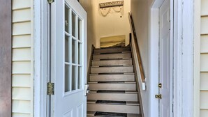 Un escalier sur lequel on peut lire l’inscription « BIENVENUE », menant à une porte dotée d’une fenêtre.