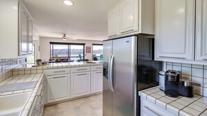 A modern kitchen with white cabinets, a stainless steel refrigerator, and a coffee maker. - Idyllic Kelseyville Home w/ 2 Decks + Views! (Kelseyville)